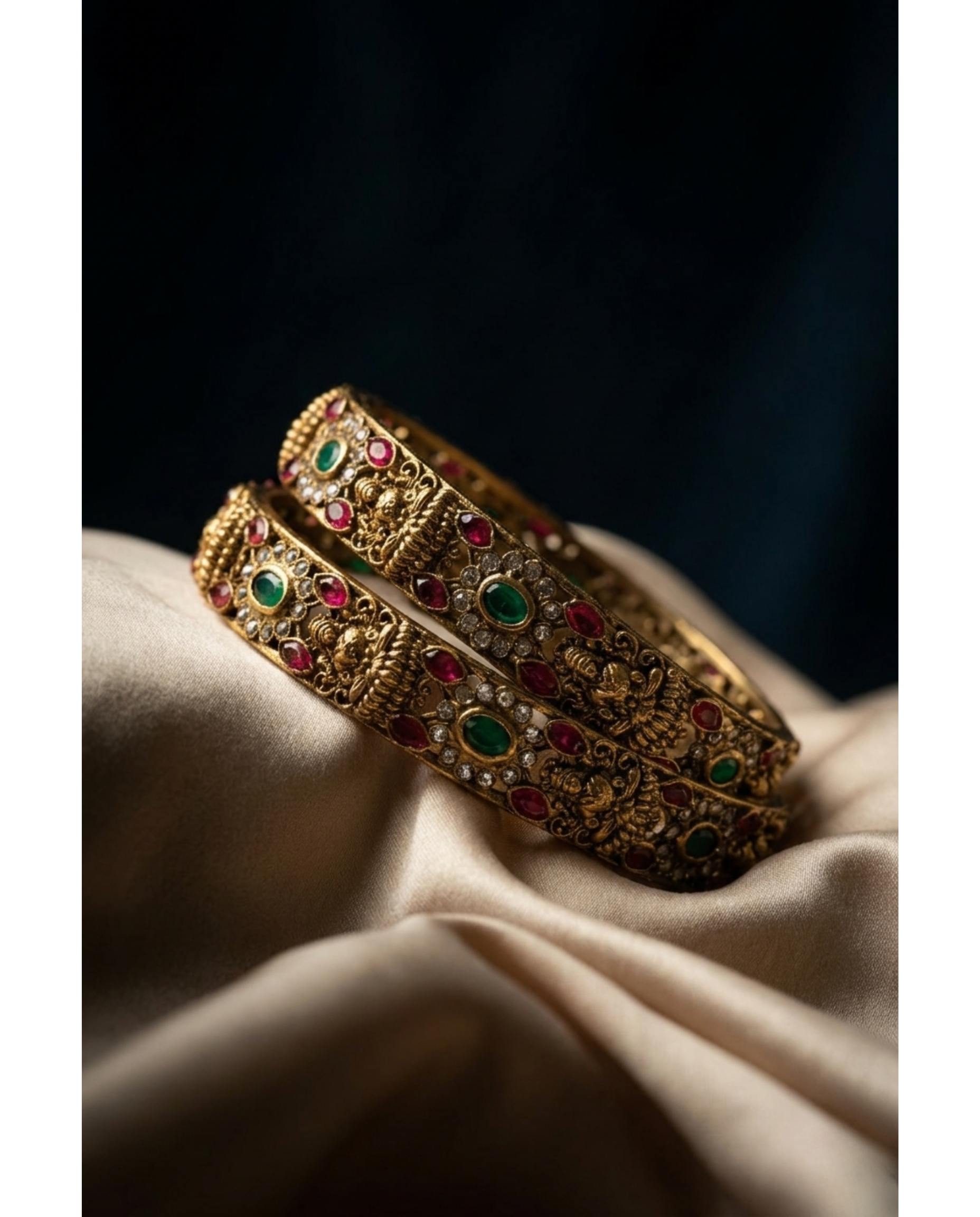 Gold bangles with gemstones on a beige fabric background