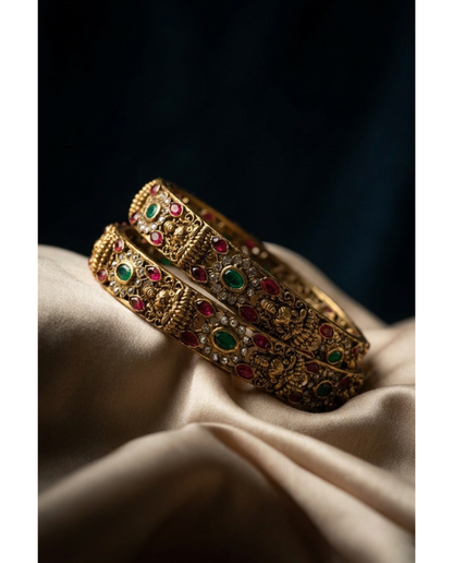 Gold bangles with gemstones on a beige fabric background