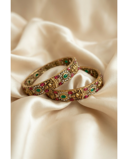 Close-up of a hand wearing gold bangles on a wooden surface
