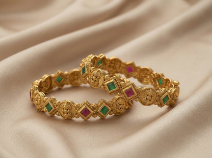 Gold bracelet with embedded gemstones on a beige fabric background