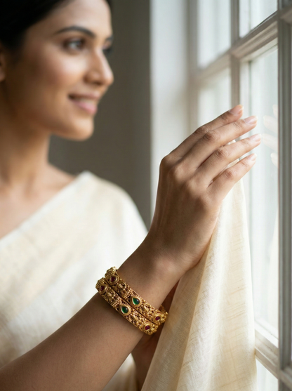 Woman wearing gold bangles by a window