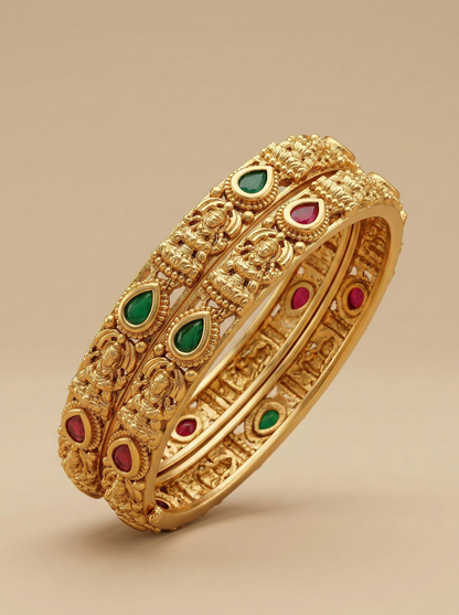 Gold bracelet with green and red gemstones on a beige background