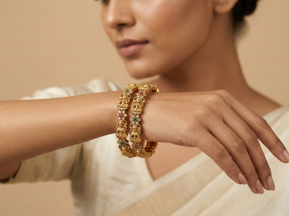 Woman wearing a gold bracelet with gemstones on a beige background