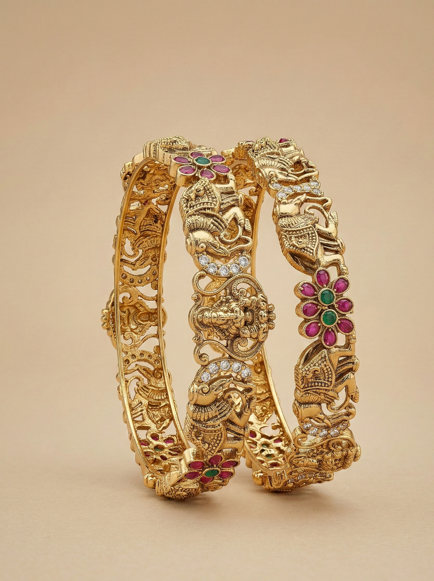 Gold bracelet with intricate designs and colorful gemstones on a beige background