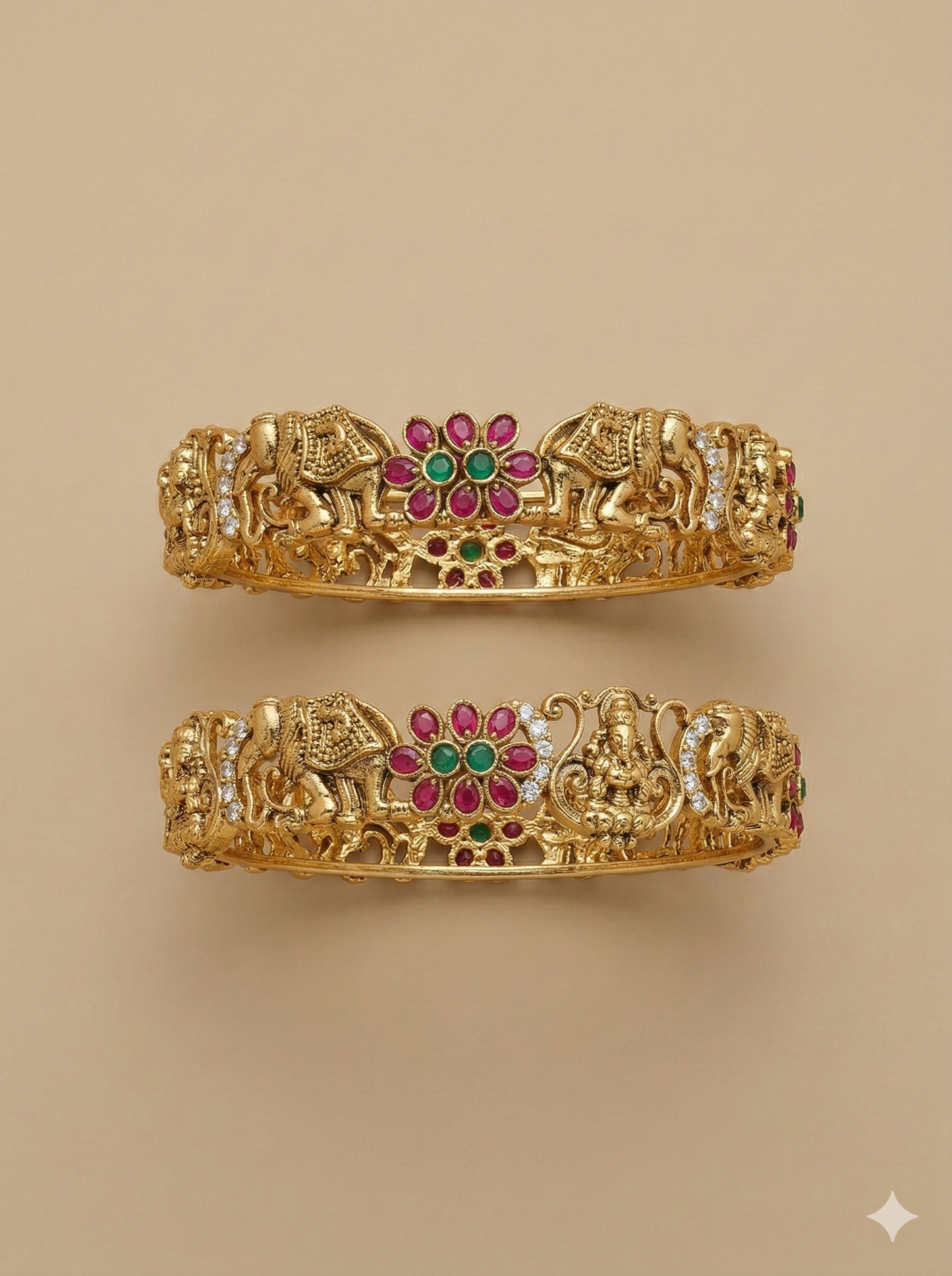 Pair of gold bangles with elephant and deity designs on a beige background