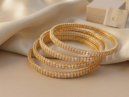 Set of gold bangles with a beige fabric background