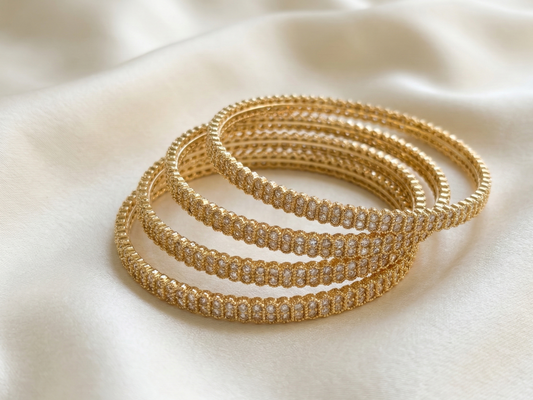 Set of gold bangles on a light fabric background