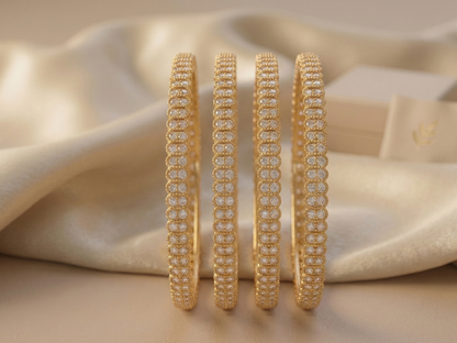 Gold bangles with diamond accents on a beige fabric background